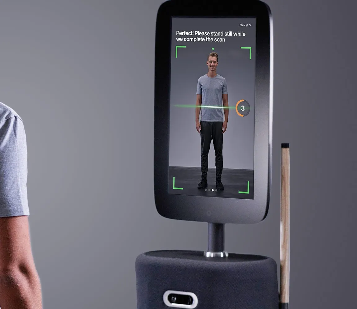 A client standing at the EGYM Fitness Hub while its camera scans them, with their outline on its screen.
